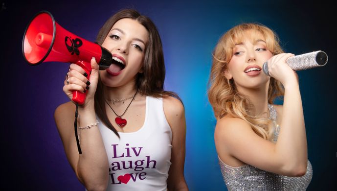 Two women, one with megaphone, one with microphone, tributes to Sabrina Carpenter and Olivia Rodrigo