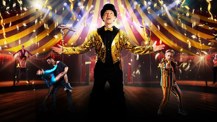 A man in a colorful circus costume stands confidently on stage, ready to entertain the audience